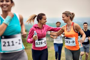 Suplementy po maratonie – uśmiechnięte kobiety biegnące w trakcie maratonu